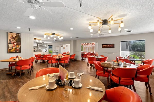 Cozy dining room with red chairs and wooden tables