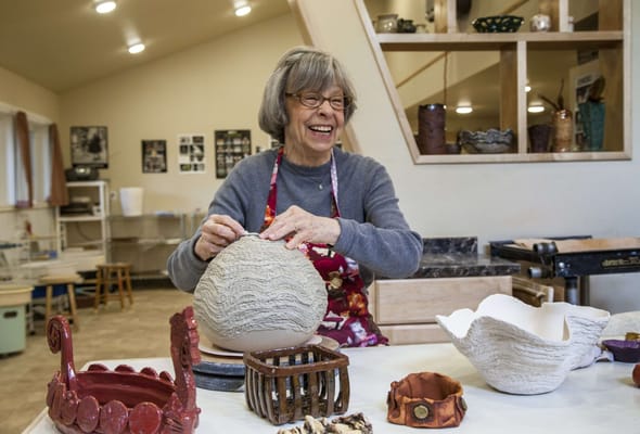 A senior woman enjoying pottery in an art room
