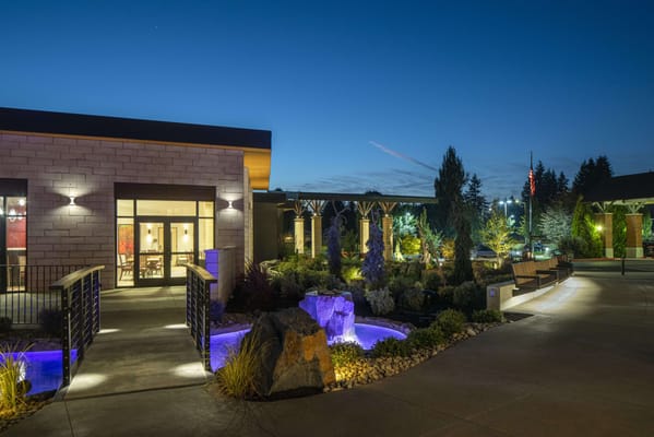 Exterior view of the facility at dusk with gardens