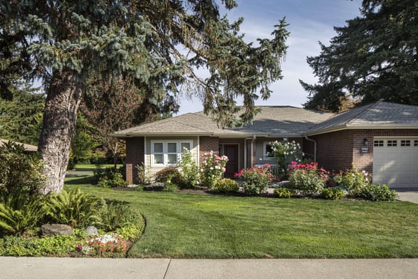Exterior view of a senior living facility surrounded by flowers