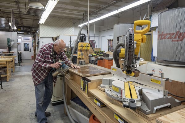 A resident working on a woodworking project in the workshop