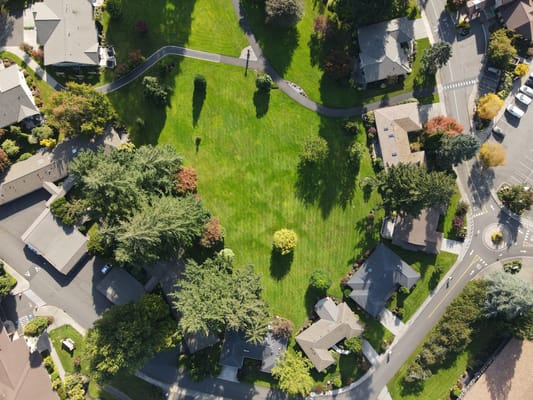 Aerial view of a senior living community with greenery and houses