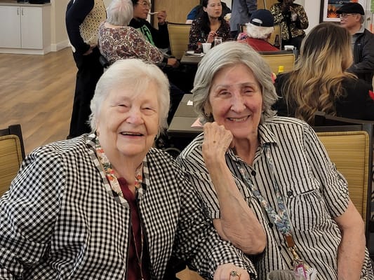 Two smiling residents enjoying a common area
