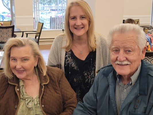 Residents and staff smiling together in a common area