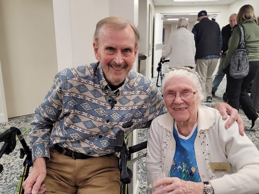 Two residents smiling together in a hallway