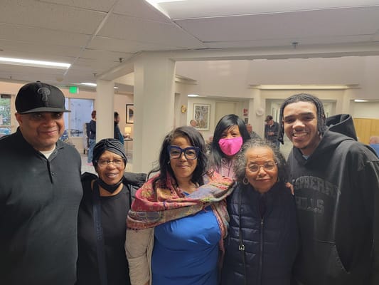 Residents and staff smiling together in a common area