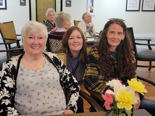 Residents and staff smiling together in a common area