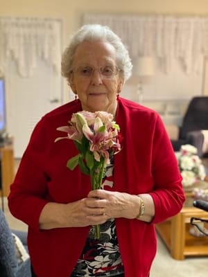 A resident holding flowers in a cozy interior