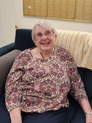 Resident smiling in a cozy lounge area