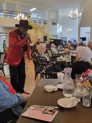A resident enjoying a performance during an event in the dining room.
