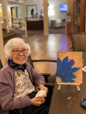 A resident painting in the activity room