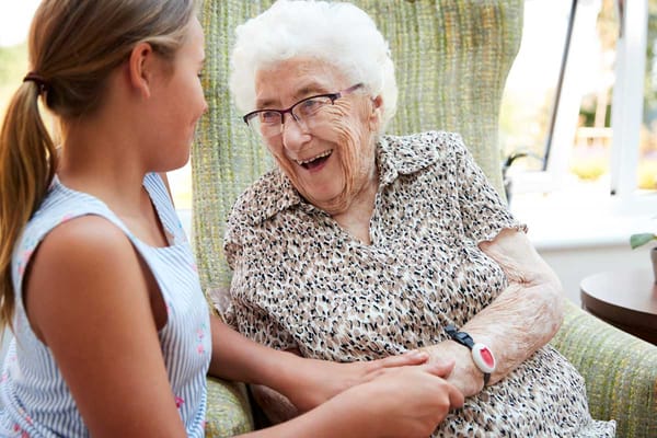 Older woman smiling with a young girl