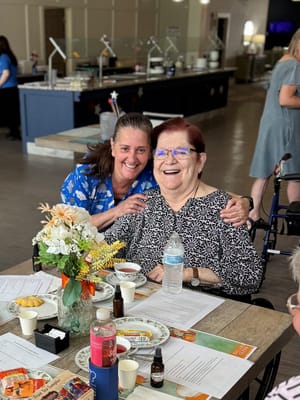 Staff member and resident sharing a joyful moment in a common area