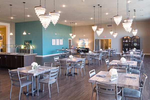 Bright dining area with elegant chandeliers and tables