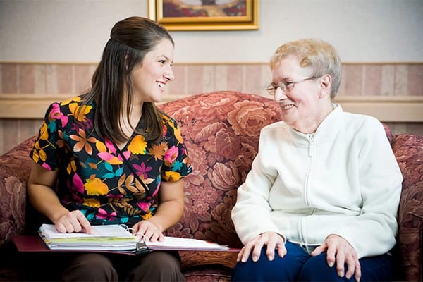 Staff member engaging with a resident in a cozy setting