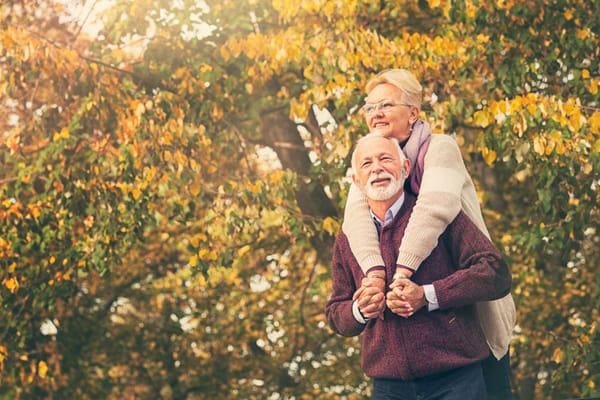 An elderly couple enjoying time outdoors during autumn.