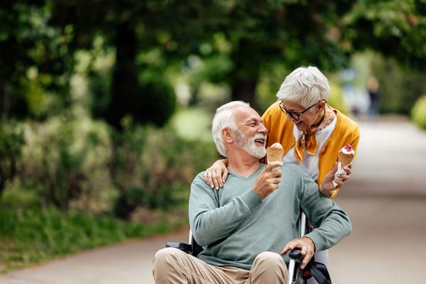 A senior man enjoying ice cream with a woman in a park