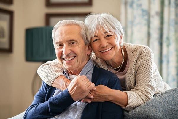 A happy older couple smiling together indoors