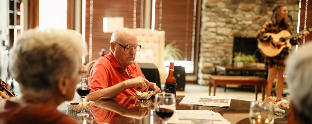 Residents enjoying a musical performance in a lounge.