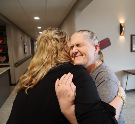 Staff member hugging a resident in a corridor