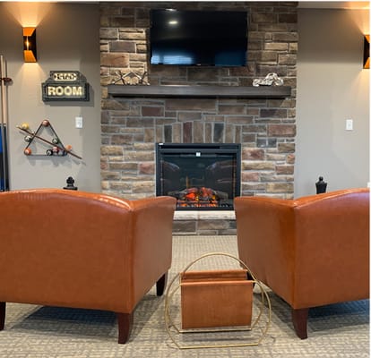 Cozy common area with chairs and a stone fireplace