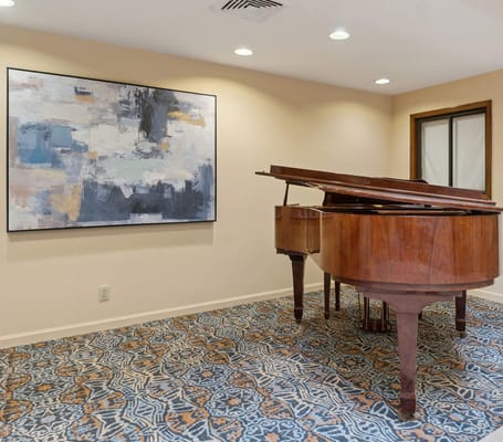 Interior view of a room with a piano and artwork