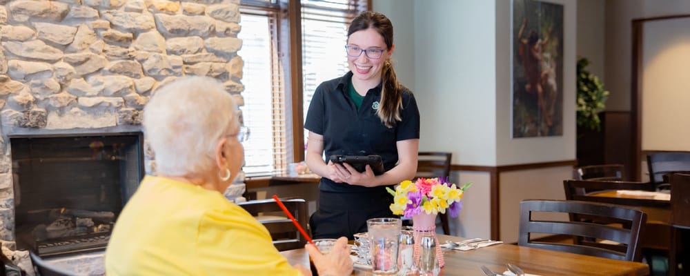 Staff serving a resident in the dining room
