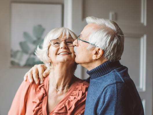 An elderly couple sharing a joyful moment indoors