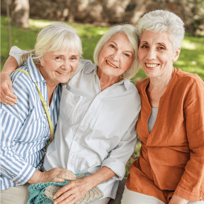 Three smiling women enjoying time together outdoors