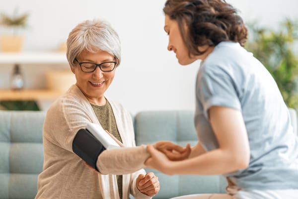 A caregiver measuring a resident's blood pressure
