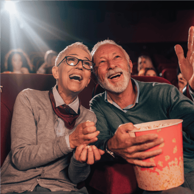 Couple enjoying a movie at a theater with popcorn