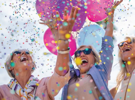 Happy residents celebrating with confetti and balloons