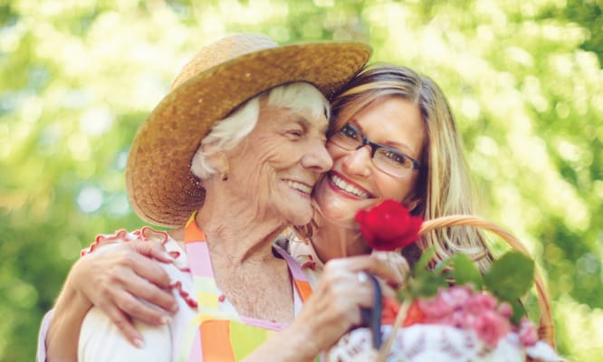 Two women enjoying a moment outdoors with flowers