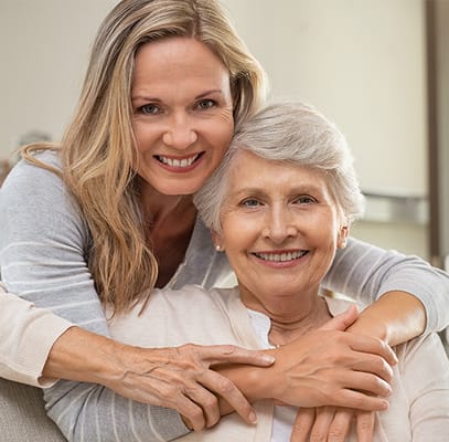 Resident and staff member smiling together in a common area