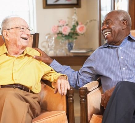 Two residents enjoying a joyful conversation in an indoor setting