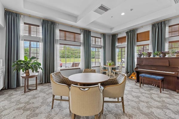 Bright common area with seating and a piano