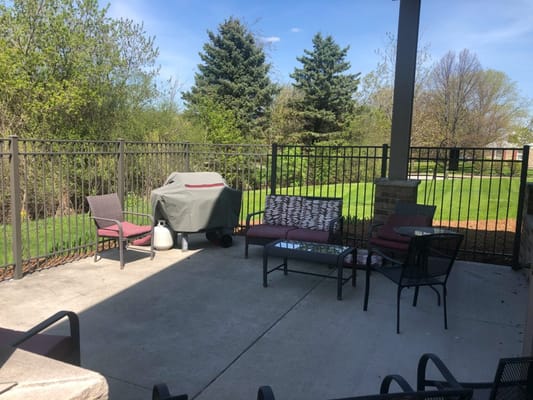 Outdoor seating area with a grill and greenery