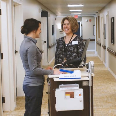 Staff member interacting with a resident in a hallway