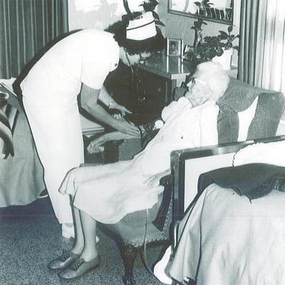 Nurse assisting an elderly resident in a care facility