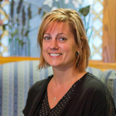 Staff member smiling in a cozy facility setting