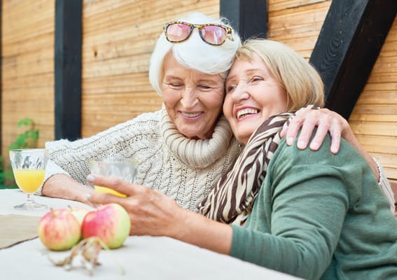 Two elderly women sharing a joyful moment together
