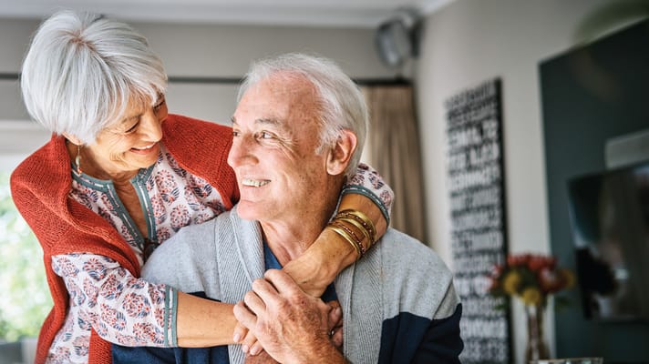 An elderly couple enjoying a moment together indoors