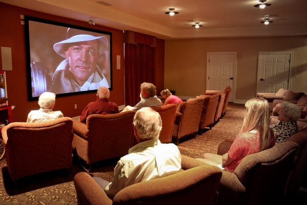 Residents watching a movie in a cozy lounge