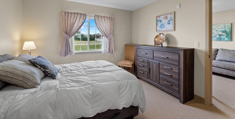 Bright private room with a bed and dresser