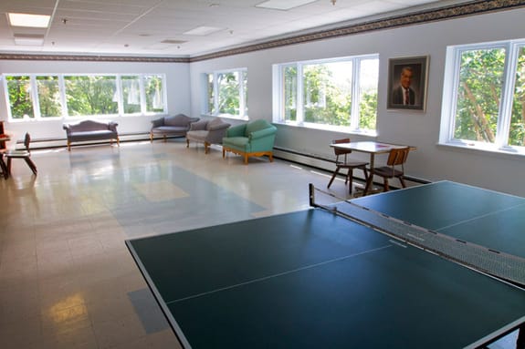 Bright common area with seating and a ping pong table