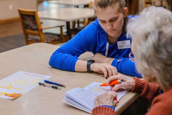 Staff member assisting a resident with a puzzle