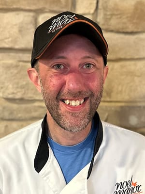 Chef smiling in a professional kitchen setting