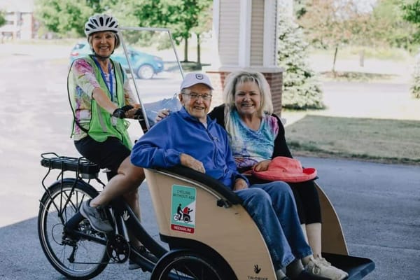 Residents enjoying a bike ride outside with volunteers