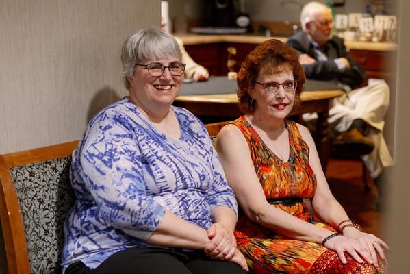 Two residents smiling while seated in a common area