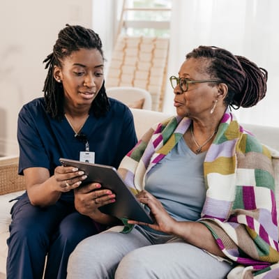 Caregiver assisting a resident with a tablet